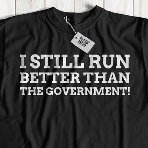 I Still Run Better Than The Government Unisex Funny Broken Leg T-Shirt | Leg Amputee Gift Ideas | Paralyzed Gifts | Wheelchair Shirt