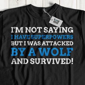 Puede incluir: Camiseta negra con texto blanco que dice "No estoy diciendo que tenga superpoderes, pero fui atacado por un lobo y sobreviví!"