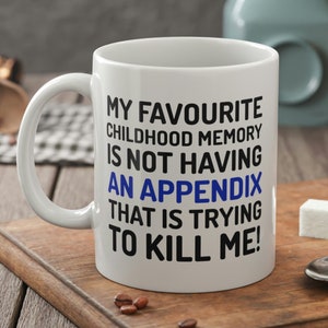 Peut inclure: Une tasse à café en céramique blanche avec du texte noir qui dit "Mon souvenir d'enfance préféré est de ne pas avoir d'appendicite qui essaie de me tuer !"