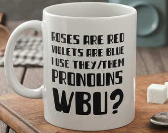 May include: White ceramic mug with black text that reads "Roses are red, Violets are blue, I use they/them pronouns, WBU?"