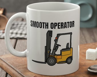 May include: White ceramic coffee mug with a black and yellow illustration of a forklift and the text "SMOOTH OPERATOR".