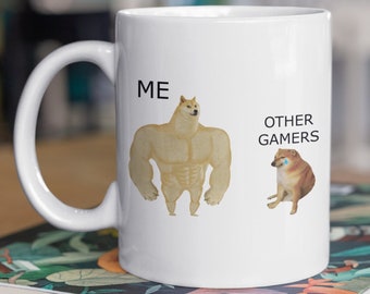 May include: White ceramic mug with a humorous meme image. The text on the mug reads "ME" and "OTHER GAMERS". The image shows a buff Doge meme character on the left and a Doge meme character with sad eyes on the right.