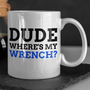May include: White ceramic coffee mug with a black and blue graphic that says "DUDE WHERE'S MY WRENCH?"