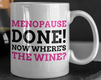 May include: White ceramic coffee mug with black text that reads "Menopause Done! Now Where's The Wine?" The text "Done!" is in large bold letters and the rest of the text is in smaller letters. The text "Menopause" is in pink.