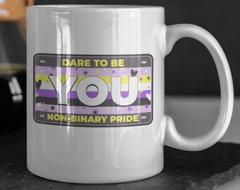 May include: White ceramic mug with a yellow, purple, and white non-binary pride flag design. The mug has a black outline and the text "Dare to be You - Non-Binary Pride".
