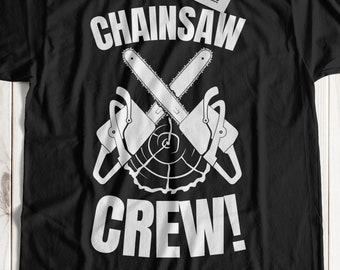 Op de afbeelding: Zwart T-shirt met een witte afbeelding van twee gekruiste kettingzagen en de tekst "Chainsaw Crew!"