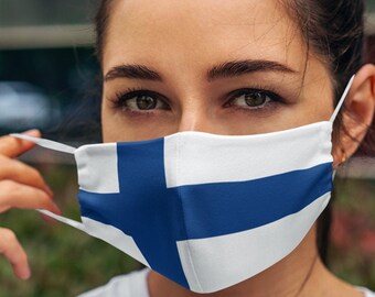 May include: A woman wearing a face mask with the Finnish flag printed on it. The mask is white with a blue cross.
