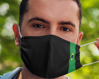 May include: A person wearing a black face mask with a green and yellow stripe and a small circle in the center. The mask has a white elastic band.