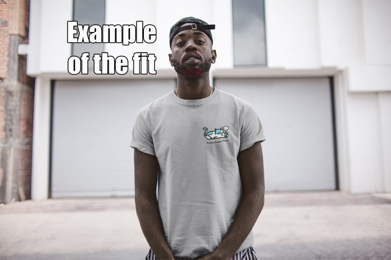 Puede incluir: Una persona lleva una camiseta gris con una ilustraci&oacute;n de dibujos animados de un coche y el texto "Ride or Die" en la parte delantera. La persona lleva una gorra de b&eacute;isbol negra y est&aacute; de pie frente a una puerta de garaje blanca.