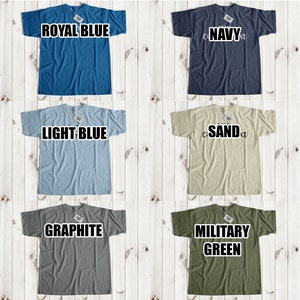 May include: A collage of 12 t-shirts in various colors, including yellow, royal blue, navy, white, black, light blue, sand, light pink/coral, ash/grey, graphite, military green, and red. Each t-shirt has a different color and is displayed on a white wooden background.