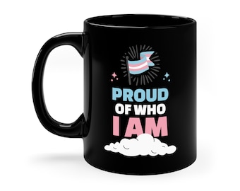 May include: Black ceramic mug with a white cloud and the text "Proud of who I am" in white. A transgender pride flag is depicted above the text.