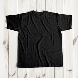 May include: A black t-shirt with short sleeves, laid flat on a wooden surface.