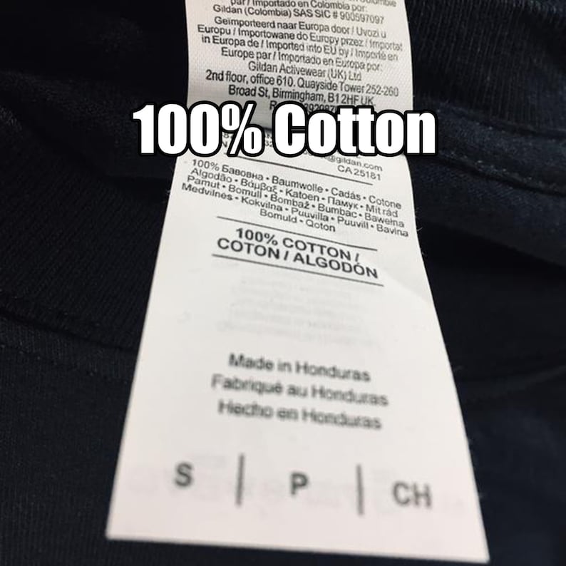 Puede incluir: Una etiqueta blanca con texto negro en una camiseta azul marino. La etiqueta dice "100% Algod&oacute;n" y enumera la composici&oacute;n de la tela en varios idiomas. Tambi&eacute;n dice "Hecho en Honduras" e incluye las tallas: S, P y CH.
