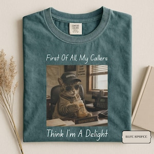 Puede incluir: Una camiseta color abeto azul con un gráfico de un gato que lleva una gorra de béisbol y gafas de sol mientras sostiene una taza de café. El texto dice First Of All, My Callers Think I'm A Delight. La camiseta tiene cuello redondo y una etiqueta Comfort Colors.