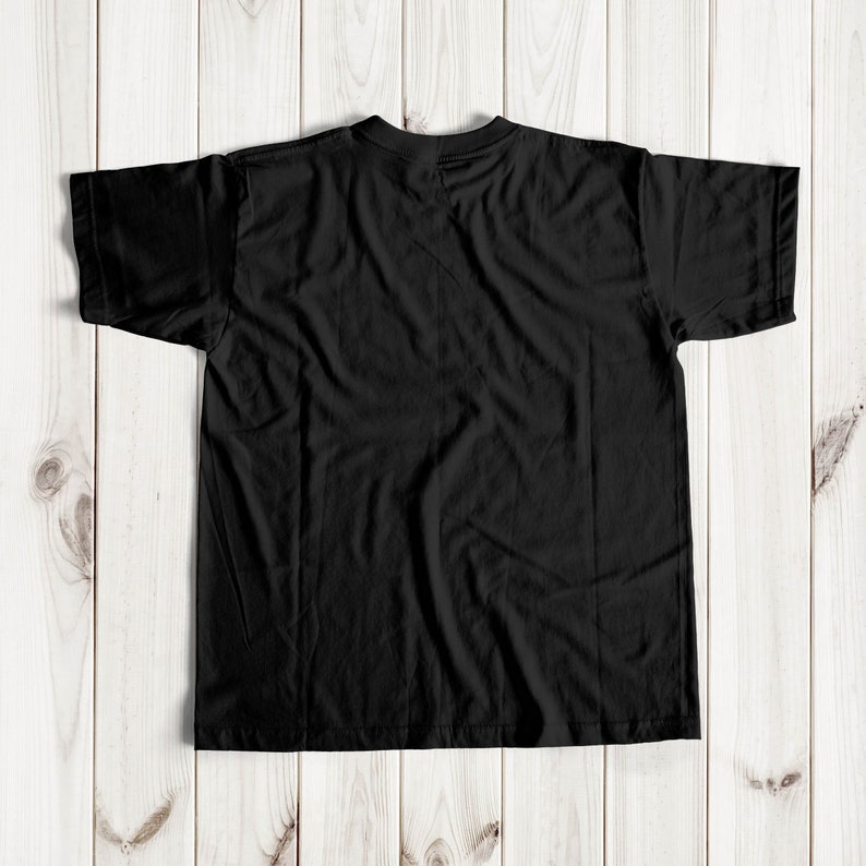 May include: A black t-shirt with short sleeves, laid flat on a wooden surface.