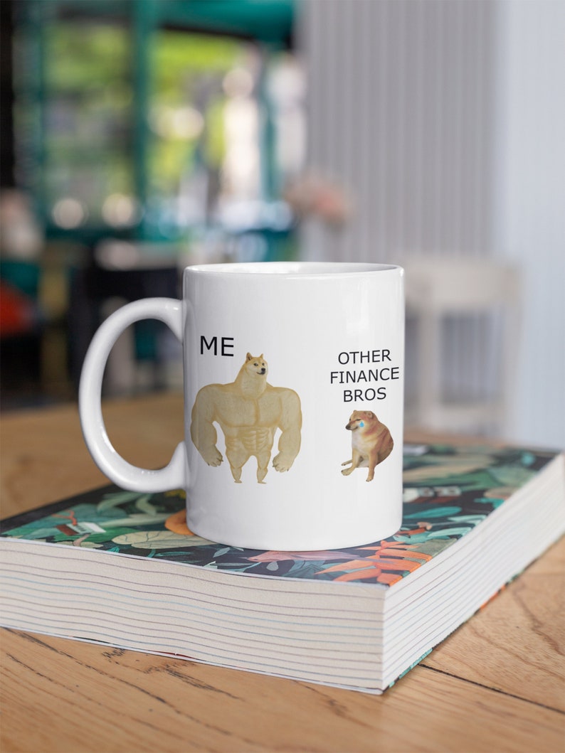 May include: White ceramic mug with a humorous illustration of two dogs. The text "ME" is next to a buff dog and "OTHER FINANCE BROS" is next to a skinny dog.