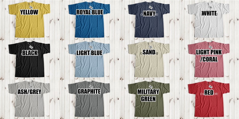 May include: A collage of 12 t-shirts in various colors, including yellow, royal blue, navy, white, black, light blue, sand, light pink/coral, ash/grey, graphite, military green, and red. Each t-shirt has a different color and is displayed on a white wooden background.