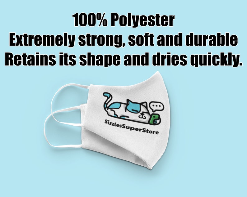 Op de afbeelding: Witte gezichtsmasker met een cartoon-kattenontwerp en de tekst "Sizzles SuperStore". Het masker is gemaakt van 100% polyester en wordt beschreven als extreem sterk, zacht, duurzaam, behoudt zijn vorm en droogt snel.