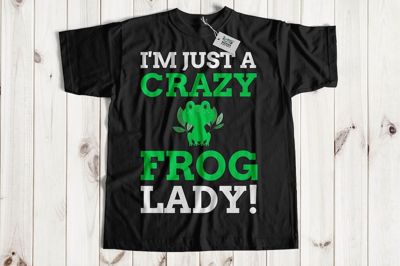 Puede incluir: Camiseta negra con un gr&aacute;fico de rana verde y el texto "I'm just a crazy frog lady!"