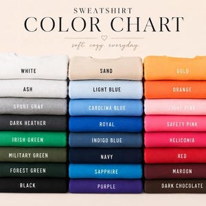 K&ouml;nnte beinhalten: Eine Sweatshirt-Farbkarte mit drei vertikalen Stapeln gefalteter Sweatshirts in verschiedenen Farben. Der Text lautet SWEATSHIRT COLOR CHART, soft. cozy. everyday., und listet Farbnamen auf, darunter White, Ash, Sport Gray, Dark Heather, Irish Green, Military Green, Forest Green, Black, Sand, Light Blue, Carolina Blue, Royal, Indigo Blue, Navy, Sapphire, Purple, Gold, Orange, Light Pink, Safety Pink, Heliconia, Red, Maroon und Dark Chocolate.