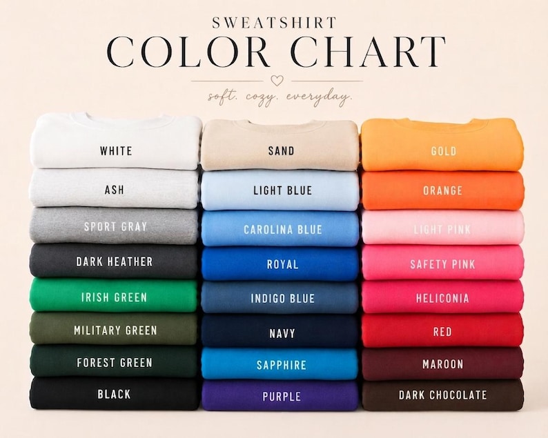K&ouml;nnte beinhalten: Eine Sweatshirt-Farbkarte mit drei vertikalen Stapeln gefalteter Sweatshirts in verschiedenen Farben. Der Text lautet SWEATSHIRT COLOR CHART, soft. cozy. everyday., und listet Farbnamen auf, darunter White, Ash, Sport Gray, Dark Heather, Irish Green, Military Green, Forest Green, Black, Sand, Light Blue, Carolina Blue, Royal, Indigo Blue, Navy, Sapphire, Purple, Gold, Orange, Light Pink, Safety Pink, Heliconia, Red, Maroon und Dark Chocolate.