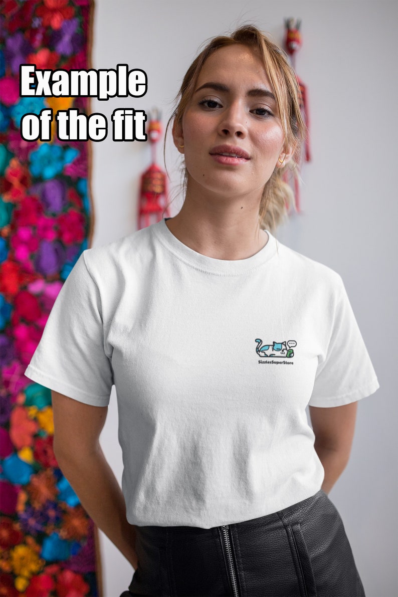 Puede incluir: Camiseta blanca con un peque&ntilde;o gr&aacute;fico de gato azul y blanco y el texto "SixtiesSuperstore" en la parte delantera.