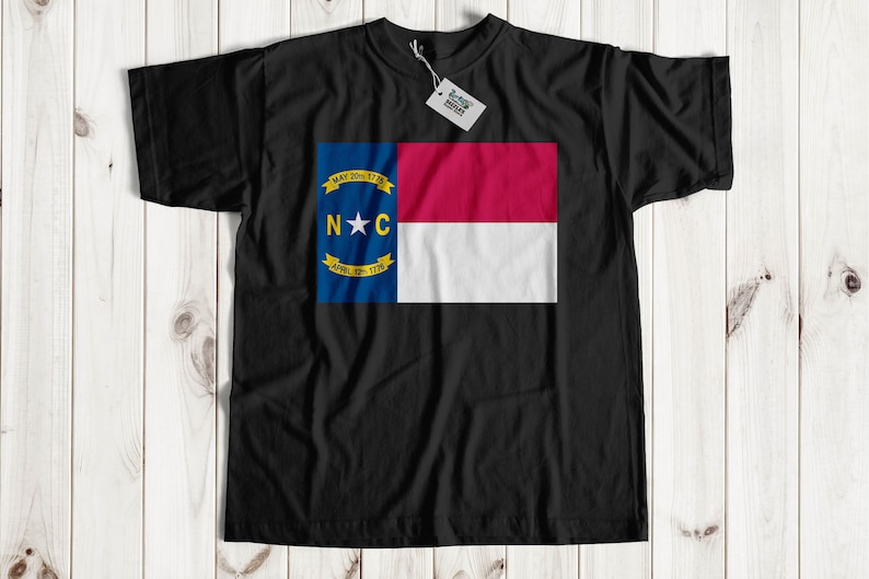 May include: Black t-shirt with the North Carolina state flag printed on the front. The flag features a red and white stripe with a blue triangle containing a white star and the letters "N.C." and the dates "MAY 20TH, 1775" and "APRIL 12TH, 1776".