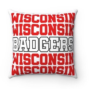 May include: White pillow with red and black text that reads "Wisconsin Badgers Wisconsin Wisconsin".