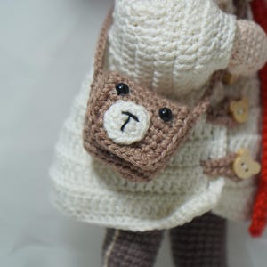 以下が含まれることがあります： 黒い持ち手と「But First, Coffee」の文字が黒い太字で書かれた白いセラミックマグ。マグカップは白い表面に置かれています。マグカップはおそらく325mlです。