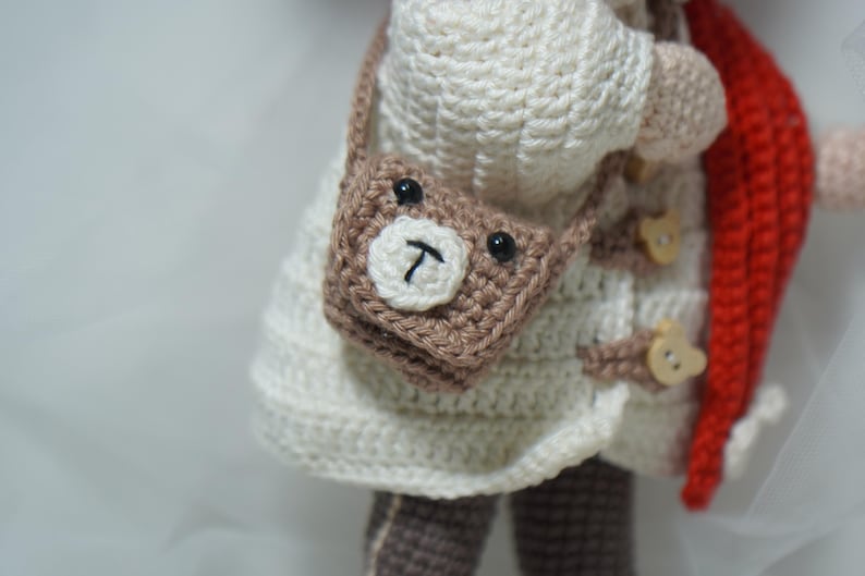 以下が含まれることがあります： 黒い持ち手と「But First, Coffee」の文字が黒い太字で書かれた白いセラミックマグ。マグカップは白い表面に置かれています。マグカップはおそらく325mlです。