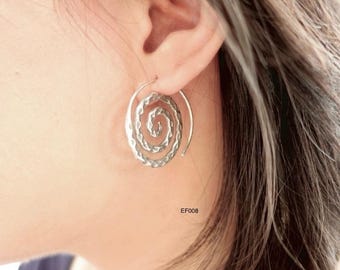 May include: Silver spiral earrings with a hammered texture. The oval-shaped earrings feature a spiral design. The text "EF008" is visible on the image. The earrings are worn on an ear.