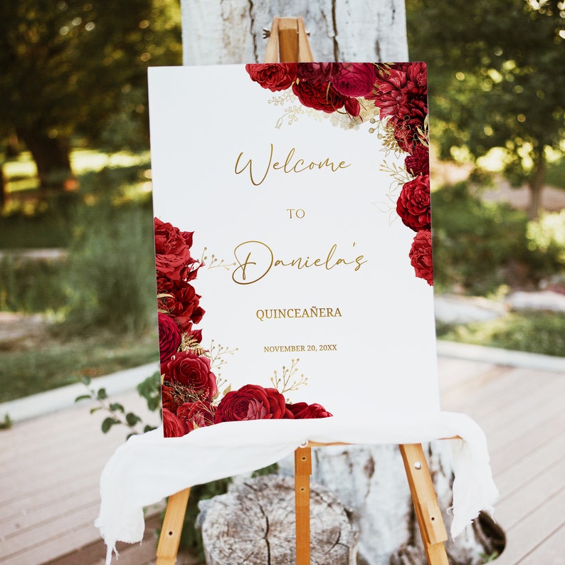 Puede incluir: Un cartel de bienvenida para el Quincea&ntilde;era de Daniela con rosas rojas y detalles dorados. El cartel dice "Bienvenida al Quincea&ntilde;era de Daniela 20 de noviembre de 20XX".