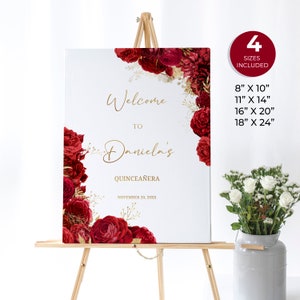 Puede incluir: Un cartel de bienvenida a Daniela's Quincea&ntilde;era con dise&ntilde;o floral rojo y dorado. El cartel est&aacute; en un caballete y el texto dice "Bienvenido a Daniela's Quincea&ntilde;era November 20, 20XX".