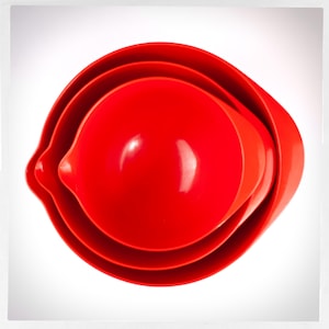 May include: A set of three red nesting mixing bowls. The bowls are made of plastic and are perfect for mixing ingredients or serving food.