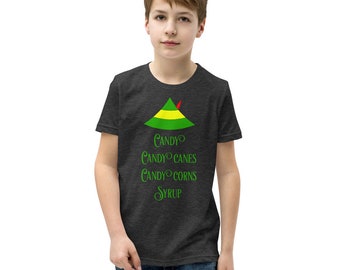May include: A dark heather grey youth t-shirt with a green and yellow elf hat graphic and the text "Candy Candy Canes Candy Corns Syrup".