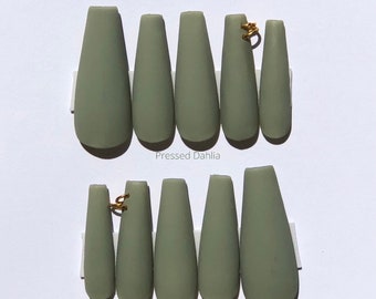 Green nails with piercings. Nail piercings, sage green nails, Thanksgiving nails, matte green nails, pierced nails, summer nails, fall nails