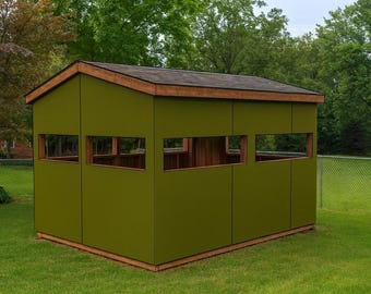 May include: A green hunting blind with a brown roof and wooden trim. The blind has rectangular windows and is set on a grassy lawn. The structure is designed for outdoor use.