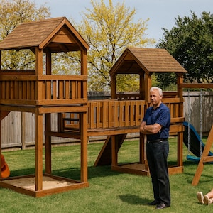 Może przedstawiać: Drewniany zestaw do zabawy ze zjeżdżalnią, dwiema wieżami i huśtawką. Zjeżdżalnia jest pomarańczowa, a konstrukcja brązowa. Mężczyzna i dziecko są w ogrodzie.