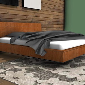 Puede incluir: Una cama flotante con una cabecera y una base de madera. La cama está hecha con un colchón blanco y una manta gris. La cama flota sobre una alfombra estampada.