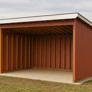 May include: A red wooden shed with white roof trim stands on a grassy field. The open-sided structure has a concrete floor and is framed with vertical wooden beams. The background features a rural landscape under a cloudy sky.