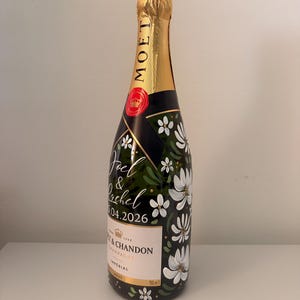 May include: A white ceramic mug with a black handle and the text "But First, Coffee" in a black, bold font. The mug is on a wooden surface. The mug is approximately 10 cm tall.