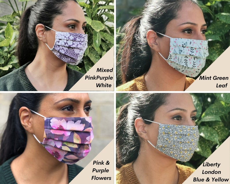 Op de afbeelding: Vier verschillende stoffen mondmaskers met verschillende patronen. De maskers zijn geplooid en hebben elastische oorlussen. De patronen omvatten gemengde roze, paarse en witte bloemen, muntgroene bladeren, roze en paarse bloemen en een blauw en geel bloemenpatroon.