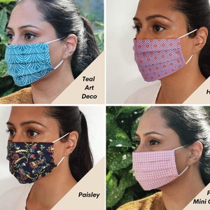 Op de afbeelding: Vier verschillende gezichtsmaskers met verschillende patronen. De maskers zijn geplooid en hebben een wit elastiek. De patronen zijn teal art deco, paarse hexagon, paisley en roze mini-gingham.