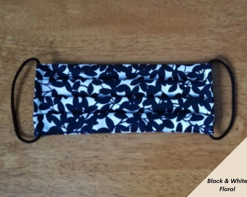 Op de afbeelding: Zwart-witte bloemen gezichtsmasker met elastische oorlussen.