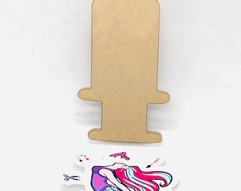 May include: A wooden cutout of a syringe with a mermaid illustration on a white background. The mermaid is wearing a purple top and has long pink and blue hair. The text "Sweet Crafting Mermaid" is written below the mermaid.