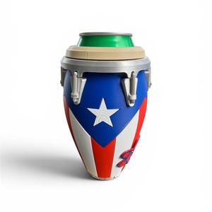 May include: A cylindrical drum-shaped beverage cooler featuring the Puerto Rican flag design with a blue triangle, a white star, and red and white stripes. The top rim is beige with a green aluminum can insert, and silver hardware accents.