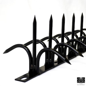 May include: Black metal security spikes, also known as a "ninja deterrent", are designed to deter intruders and protect property. The spikes are mounted on a flat metal base and are angled upwards.