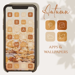 Puede incluir: Un teléfono inteligente muestra una interfaz con temática otoñal con iconos de aplicaciones en tonos marrones y naranjas. La pantalla muestra aplicaciones como Etsy, Pinterest y Spotify. También se ven las palabras "Autumn" y "APPS & WALLPAPERS".