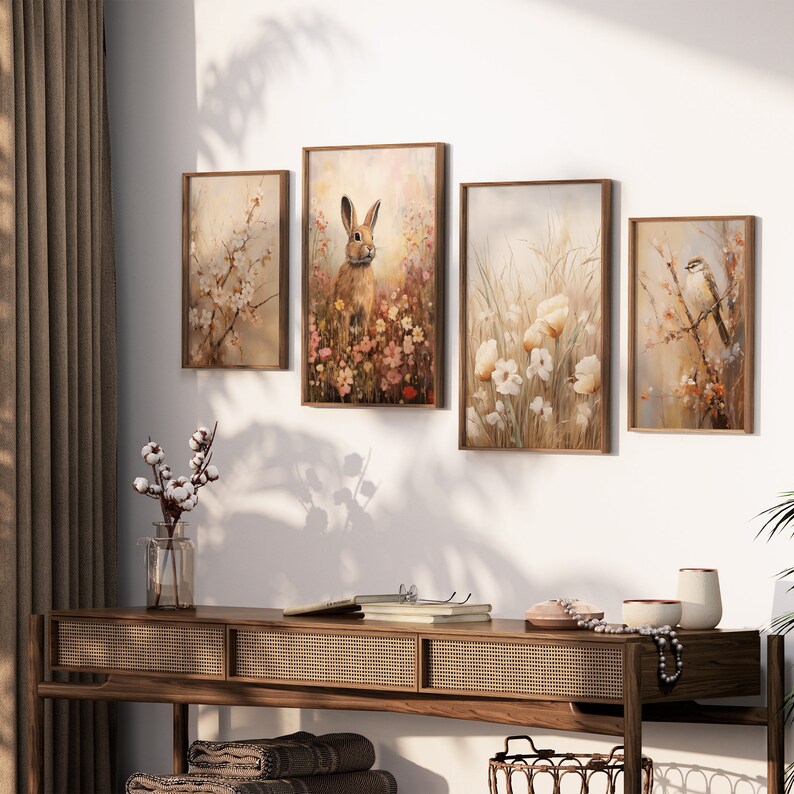 May include: Set of four framed nature-themed prints featuring a rabbit in a field of flowers, a field of white flowers, a bird on a branch, and a branch with white blossoms. The prints are in brown frames and are hung on a white wall.