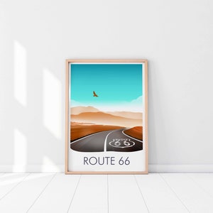 May include: A framed print of a desert landscape with a road leading to a Route 66 sign. The sky is blue and there is a bird flying in the distance. The text "ROUTE 66" is printed below the image.